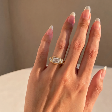 East West Emerald Cut Diamond Bezel Ring With Trapezoid Side Stones